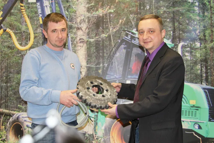 Преподаватель Томского лесотехнического техникума Константин Синюхин (справа) изучает устройство харвестера «Амкодор». фото